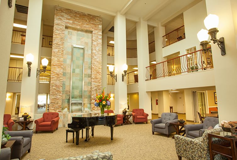 A spacious and elegantly designed lobby featuring a grand piano and comfortable seating.