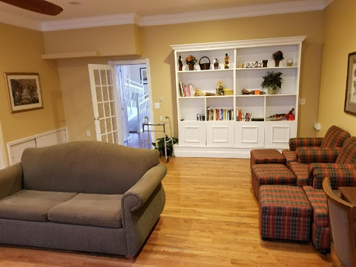 A cozy living room featuring a comfortable sofa, a stylish bookshelf, and warm wooden flooring.