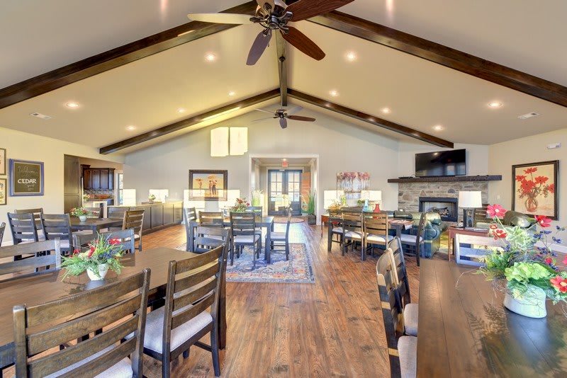 A spacious, modern living and dining area with a vaulted ceiling and wooden floors.