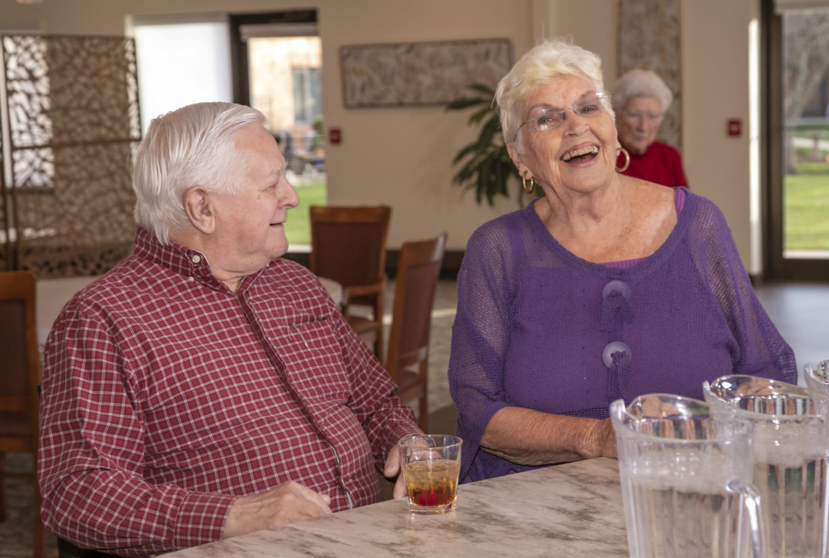 A group of elderly individuals enjoying a conversation indoors.