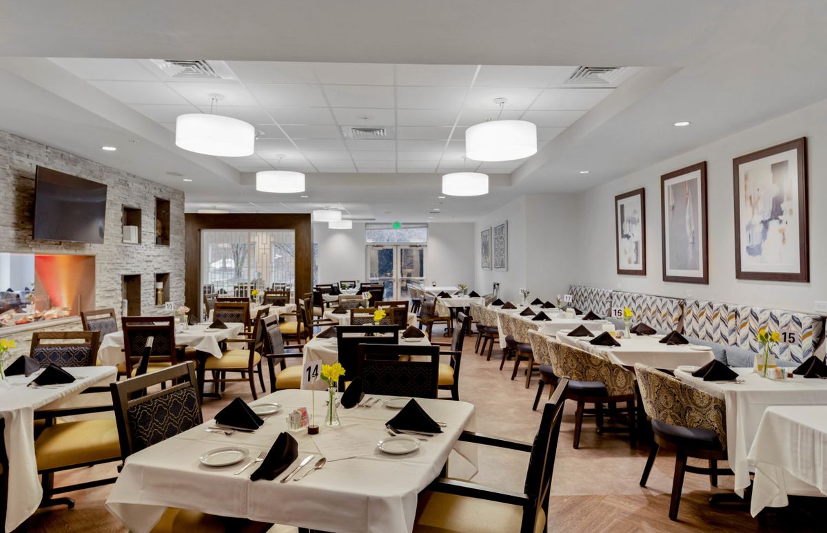 A well-arranged dining room in a restaurant with neatly set tables and chairs.