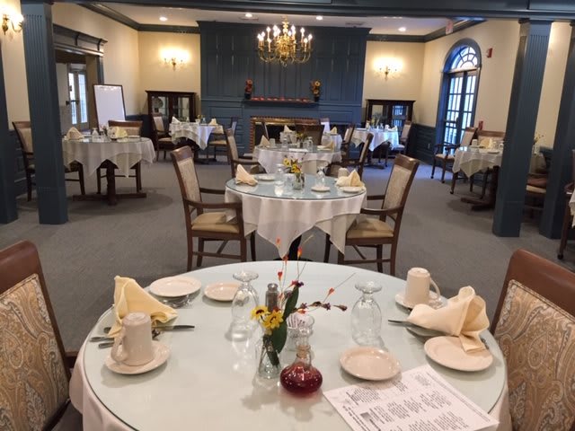 An elegant dining room with multiple tables set for a formal meal.