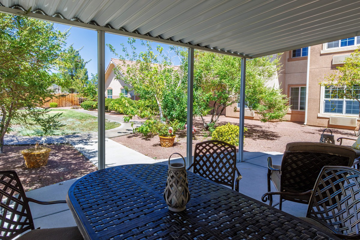 A cozy patio overlooking a lush backyard garden with outdoor seating.