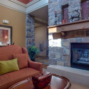 A cozy living room featuring a stone fireplace and comfortable seating.