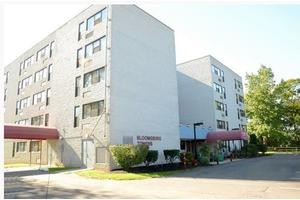 A view of a residential apartment building with multiple floors and red awnings.