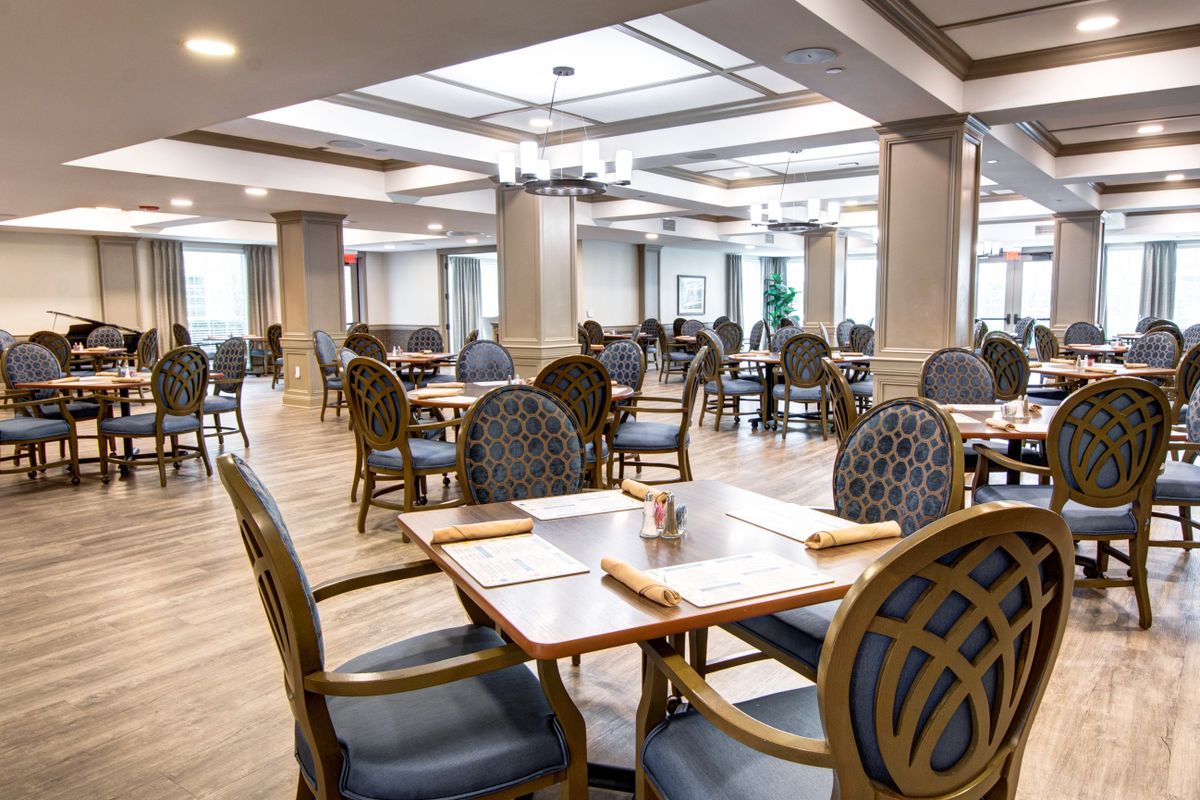 An empty restaurant dining area with neatly arranged tables and chairs.
