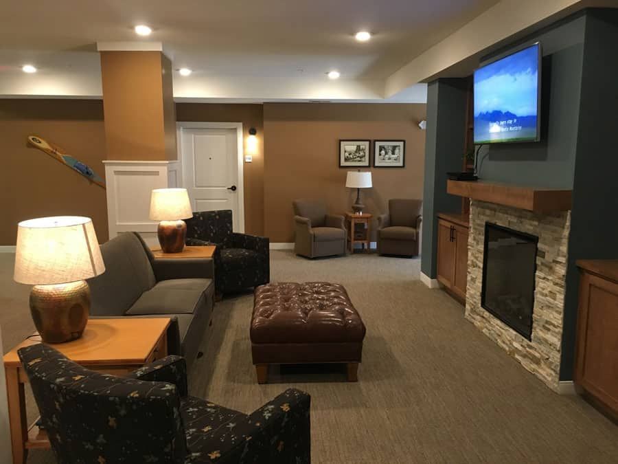A cozy living room featuring a fireplace, comfortable seating, and a wall-mounted television.