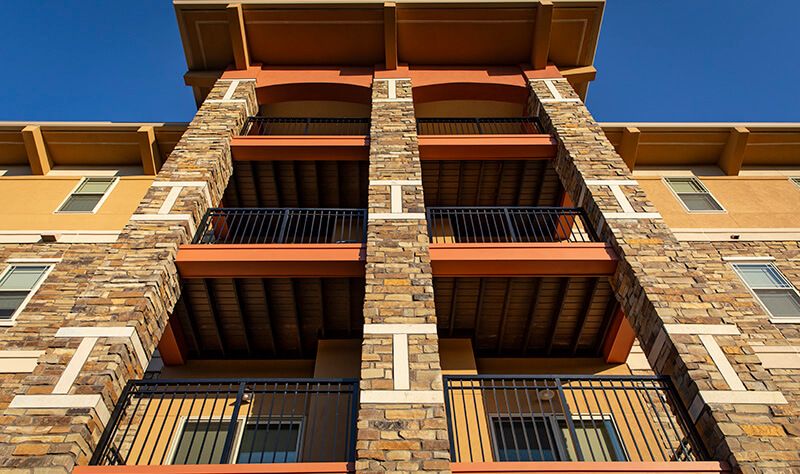 A multi-story building with a stone facade and balconies.