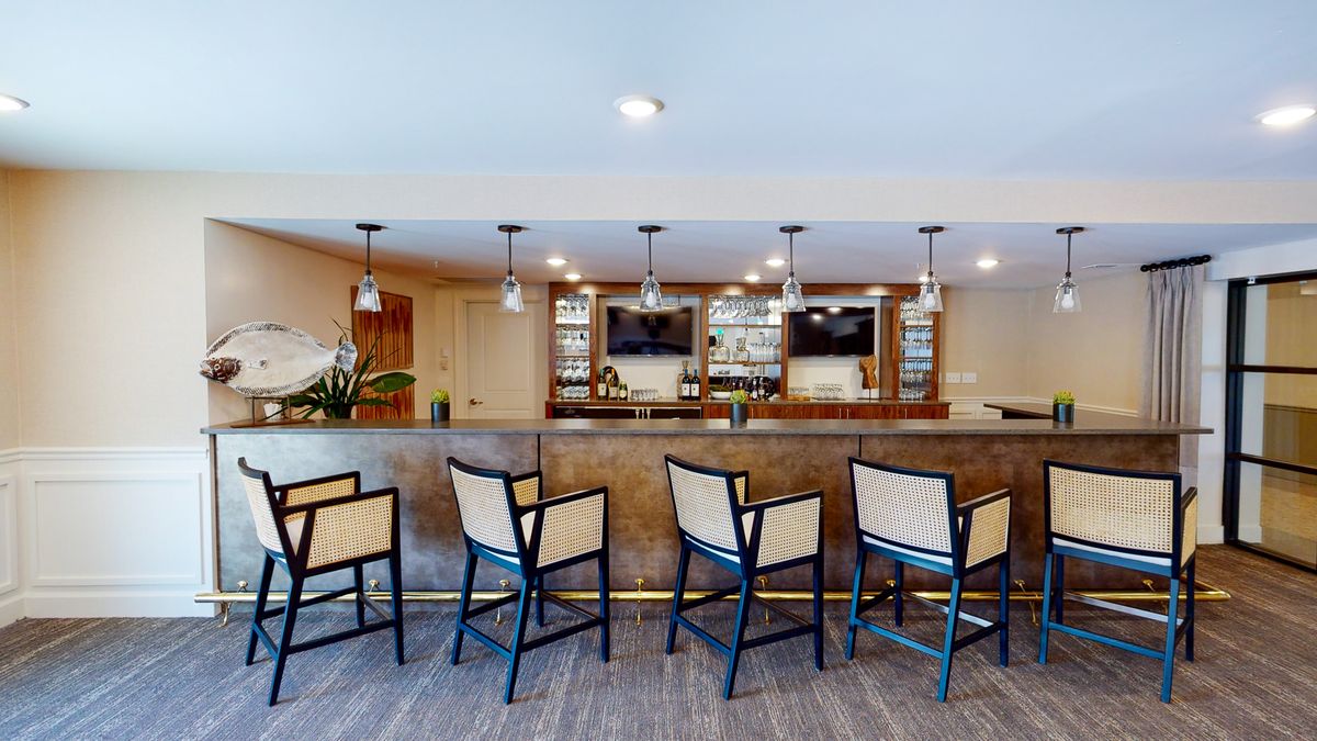 A modern bar area with seating and elegant lighting.