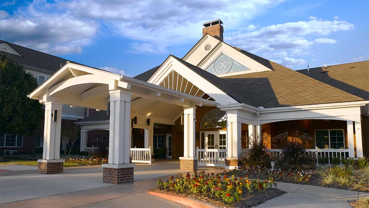 A beautiful residential building with a grand entrance and landscaped surroundings.