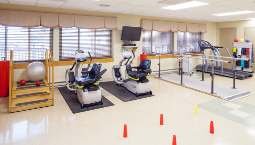 A rehabilitation gym featuring exercise bikes and a spacious area for physical therapy activities.