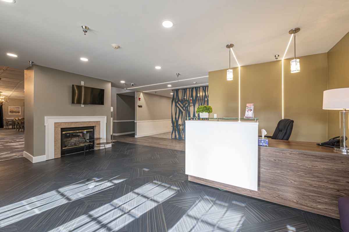 A modern lobby with a sleek reception desk and contemporary lighting.