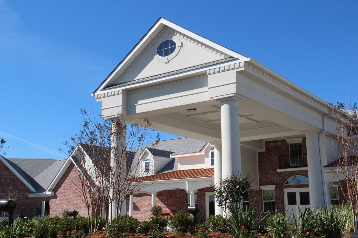 A large residential building with a prominent entrance and columns.
