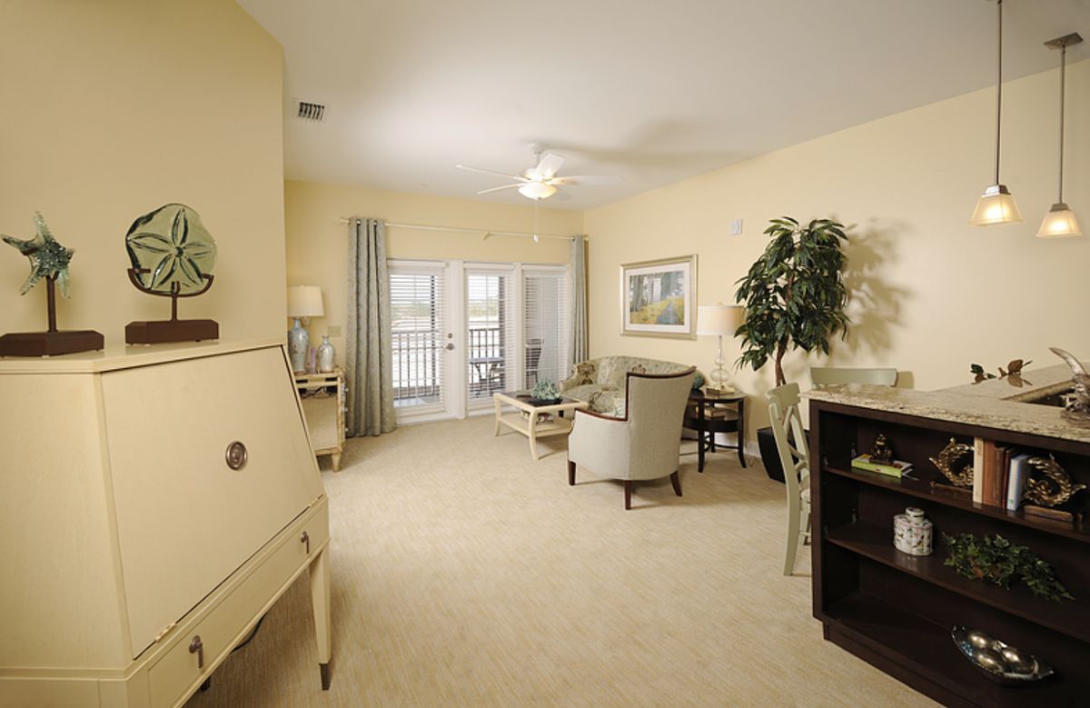 A cozy and elegantly furnished living room with neutral tones and abundant natural light.