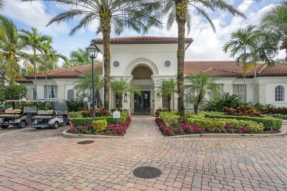 A grand entrance with palm trees and vibrant landscaping.