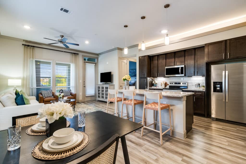 A modern open-concept living room and kitchen space with neutral color tones and contemporary furnishings.