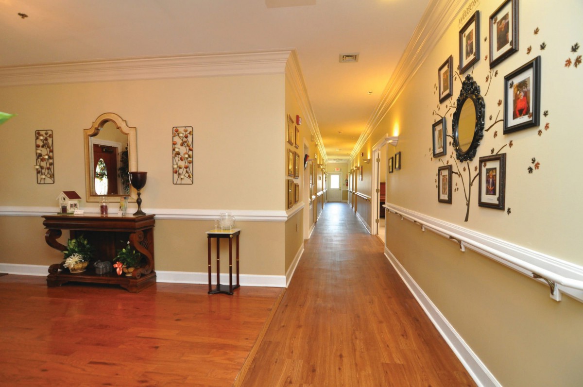 A beautifully decorated hallway with hardwood floors and wall art.