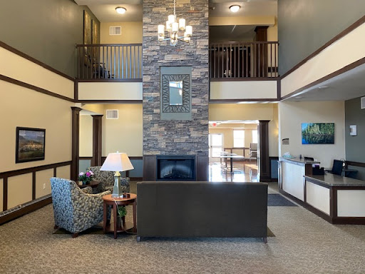 A modern lobby featuring elegant furniture and a stunning stone wall, creating a welcoming atmosphere.