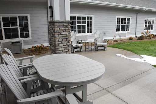 A cozy outdoor seating area featuring a gray table and chairs next to a residential building.