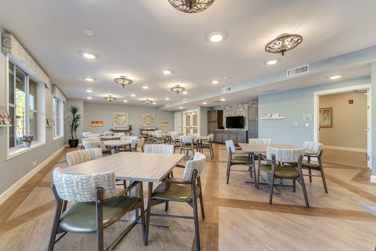 A spacious and modern indoor dining area with tables and chairs arranged neatly under bright lighting.
