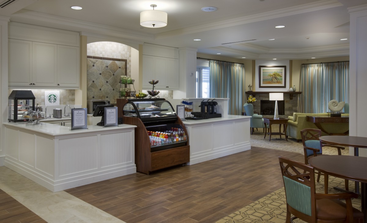 A cozy lobby area featuring a cafe with seating and elegant decor.