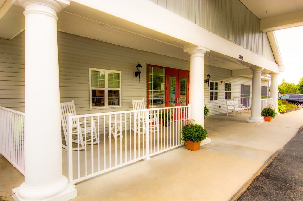 Inviting front porch with rocking chairs and bright red doors.