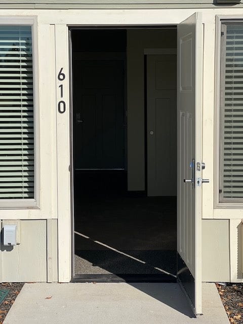 An open door with the number 610 on a building's entrance.