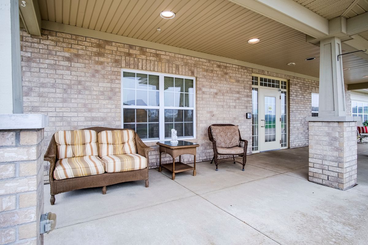 A cozy patio with comfortable seating arranged under a covered porch.