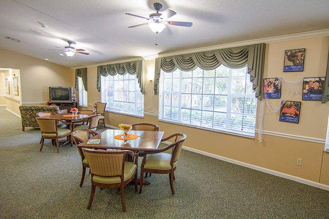A cozy dining room with a table set and large windows.