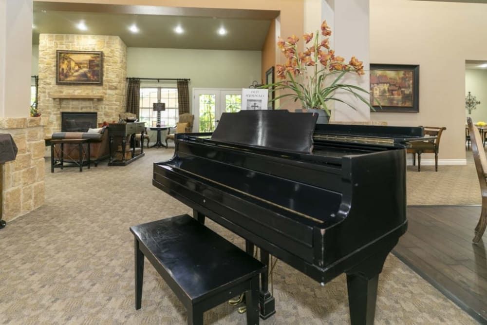 A grand piano in a spacious living room interior, featuring elegant decor and natural lighting.