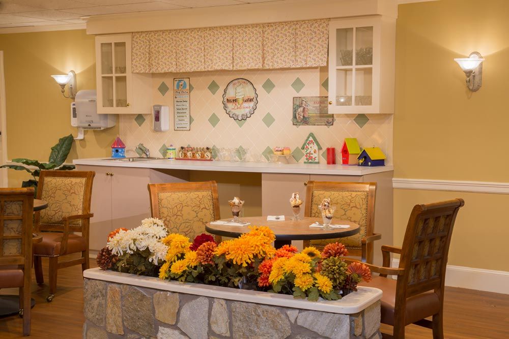A cozy indoor kitchen and dining area adorned with vibrant flowers and charming decor.