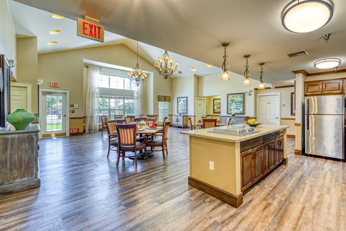 A spacious and well-lit dining and kitchen area with modern fixtures and large windows.