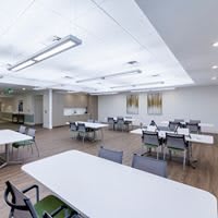 A modern conference room with multiple tables and chairs arranged for meetings.