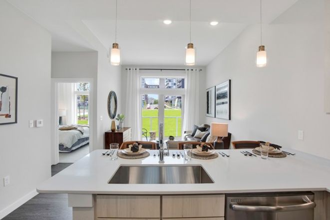 A modern open-concept kitchen and living room with sleek design and stylish lighting.