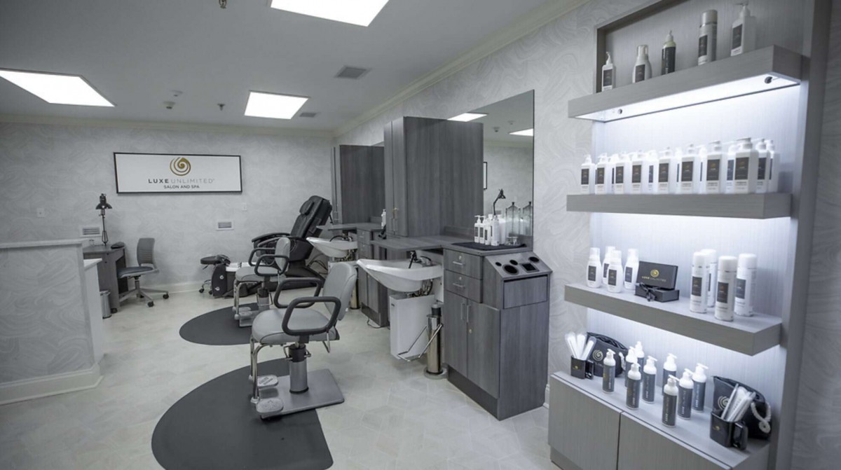 A modern barbershop interior with styling chairs and hair care products displayed.
