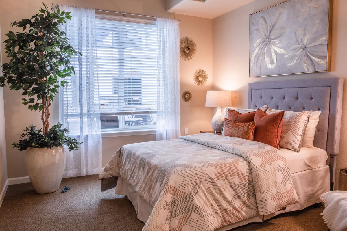 A cozy and well-decorated bedroom featuring a comfortable bed, soft lighting, and elegant decor.