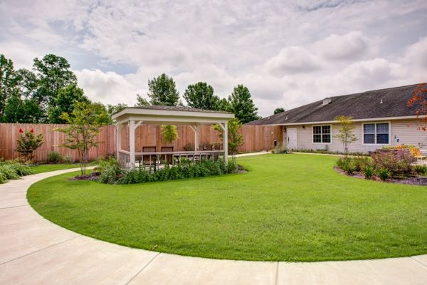 A neatly landscaped backyard featuring a gazebo and well-maintained lawn.