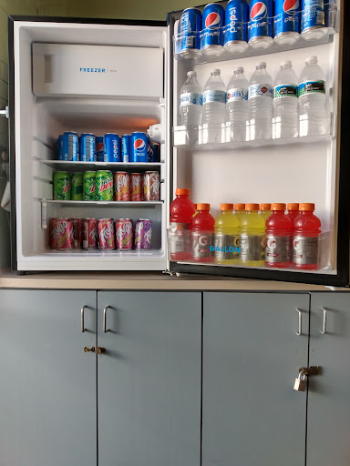 A well-stocked fridge featuring a variety of beverages including sodas, sports drinks, and bottled water.