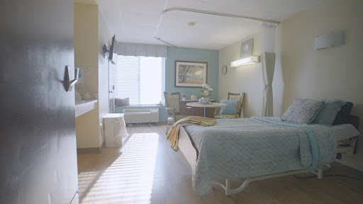 A serene and well-lit hospital room featuring modern furnishings and a comfortable atmosphere.