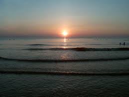 A serene sunset over calm ocean waves.