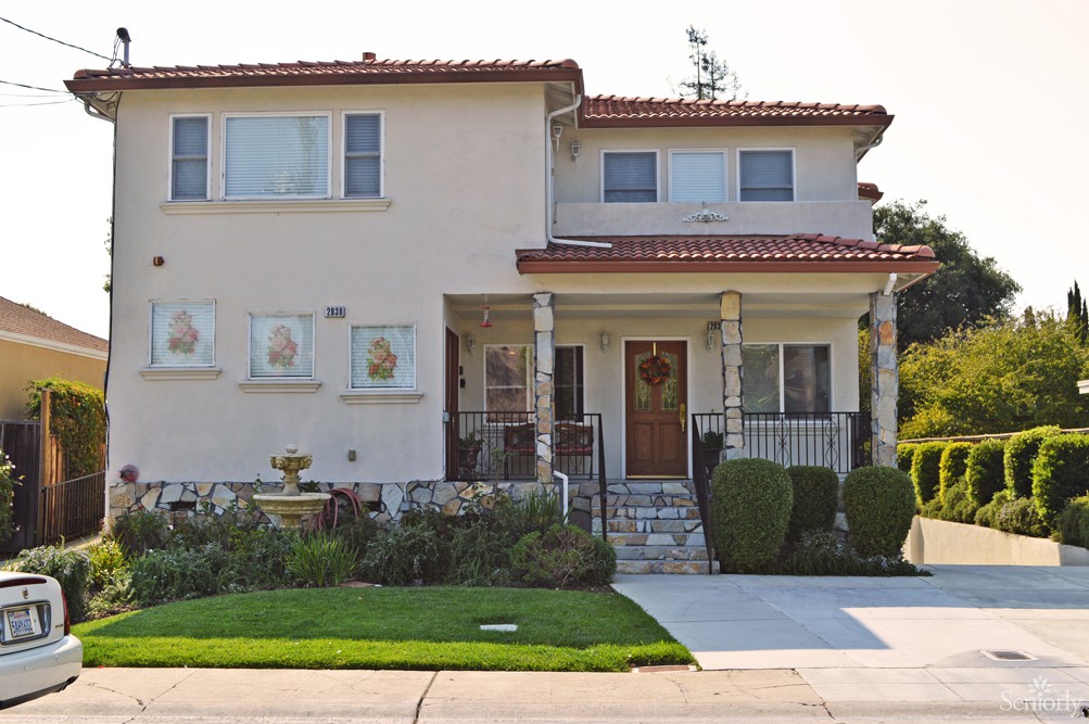 A two-story residential house with a well-maintained lawn and driveway.