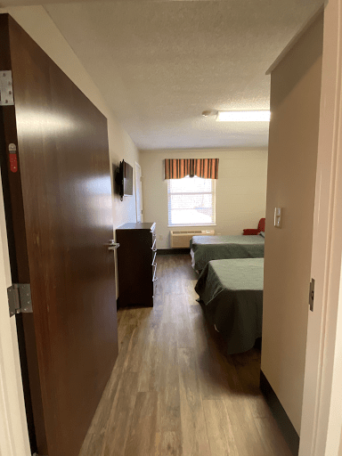 A cozy hotel room with two beds, a television, and a window.