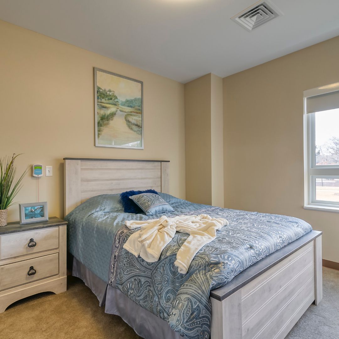 A cozy bedroom with a neatly made bed and soothing decor.