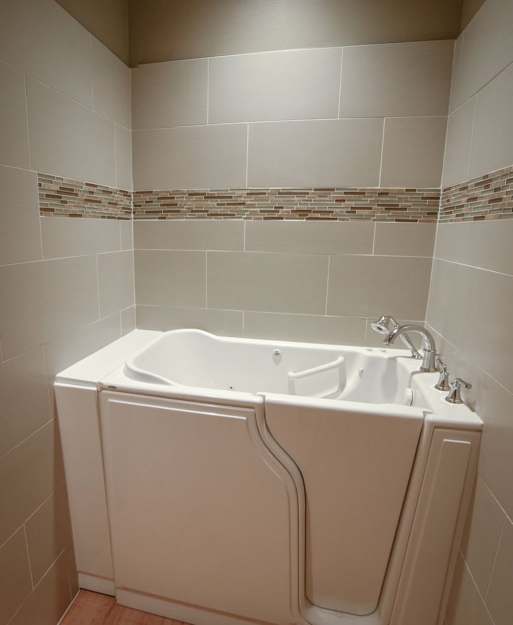A bathroom featuring a walk-in bathtub with modern tile accents.