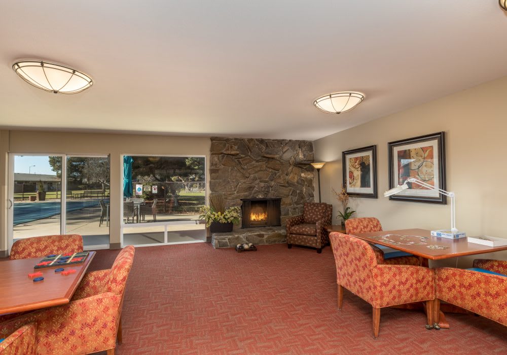 A cozy living room with a fireplace, comfortable seating, and decorative artwork.