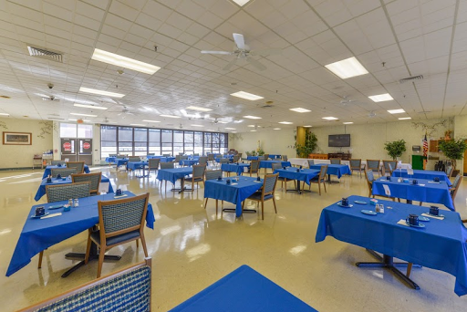 A spacious dining area featuring blue tablecloths and ample seating.