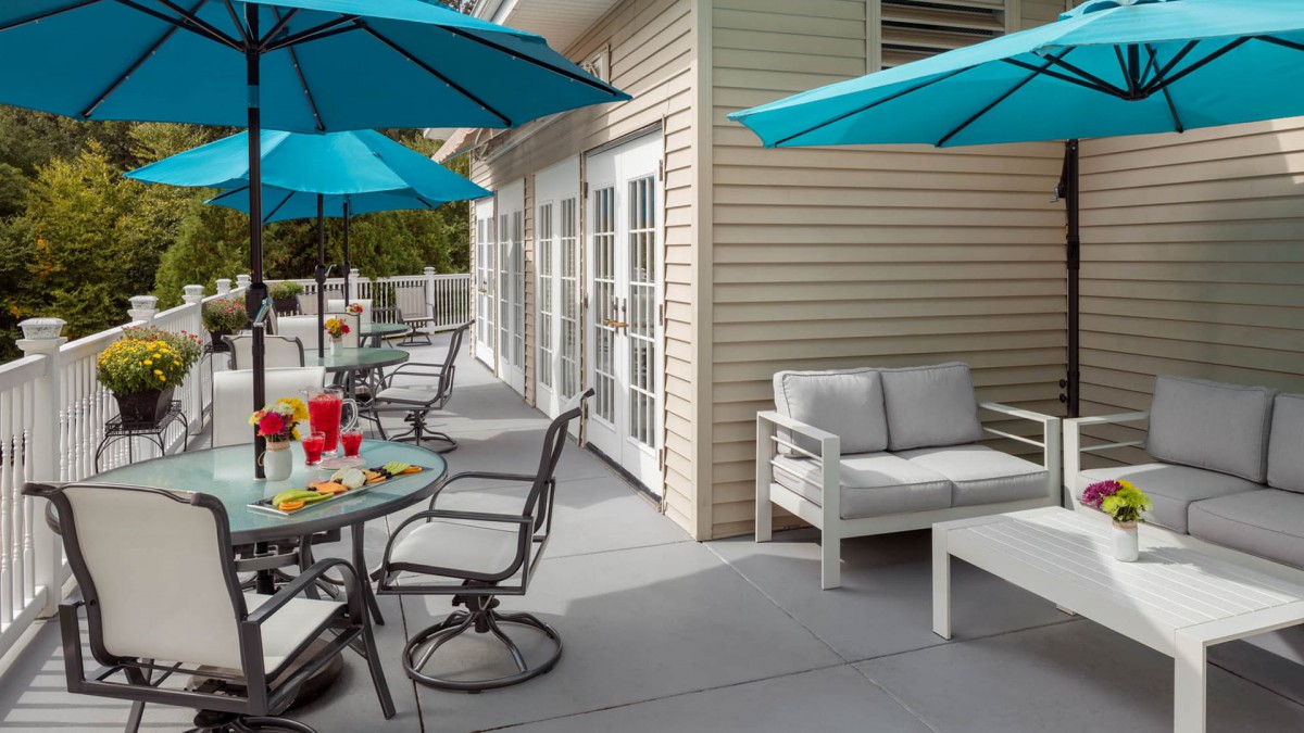 A cozy outdoor patio area with blue umbrellas and comfortable seating.