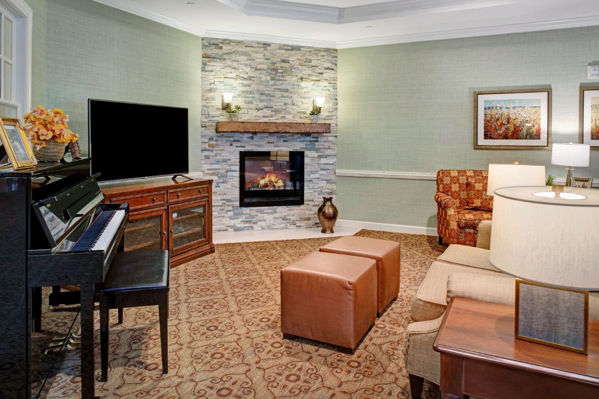 A cozy living room with a piano, modern furniture, and a fireplace.