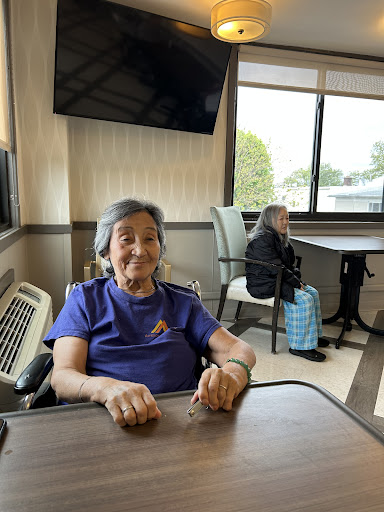 Two elderly women enjoying their time together in a care facility.