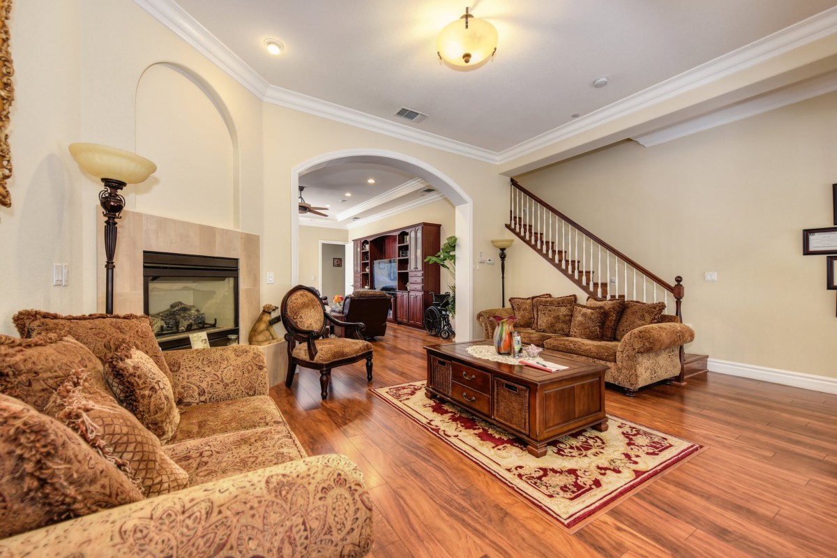 A cozy living room featuring classic furniture, a fireplace, and wooden flooring.